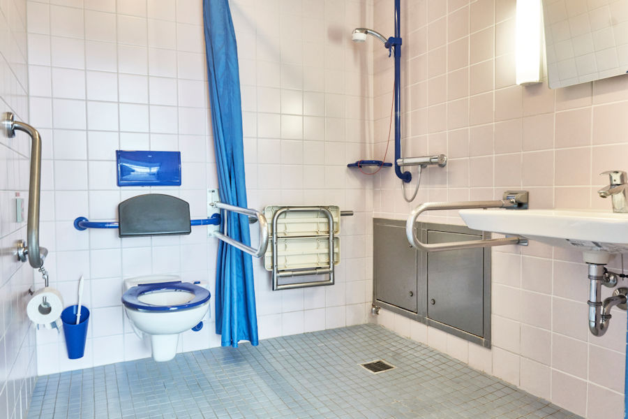 Barrierefreies Badezimmer mit Waschbecken, Dusche und WC Barrierefreies Badezimmer mit Waschbecken, Dusche und WC